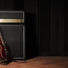 Red electric guitar and classic amplifier on a dark background